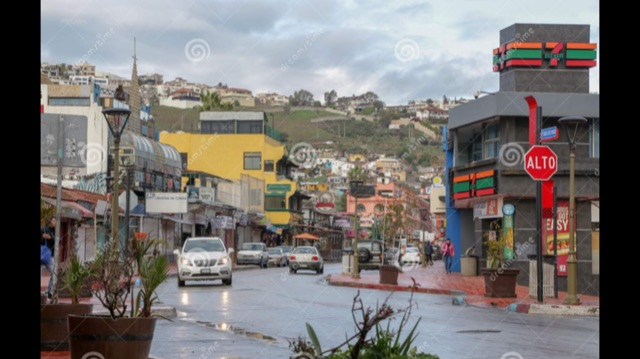 A street with some shops and moving vehicles