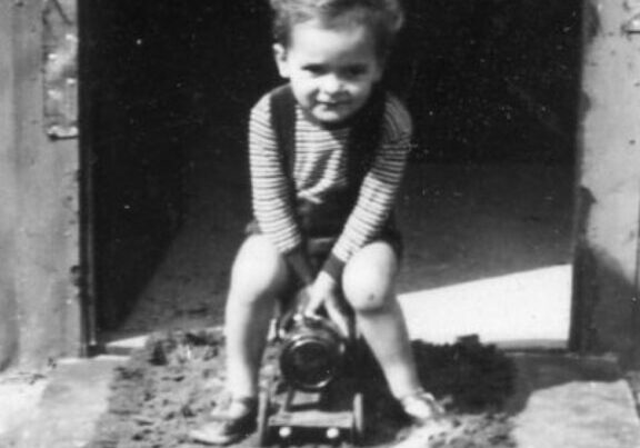 Ancient image of a small boy sitting on a small train